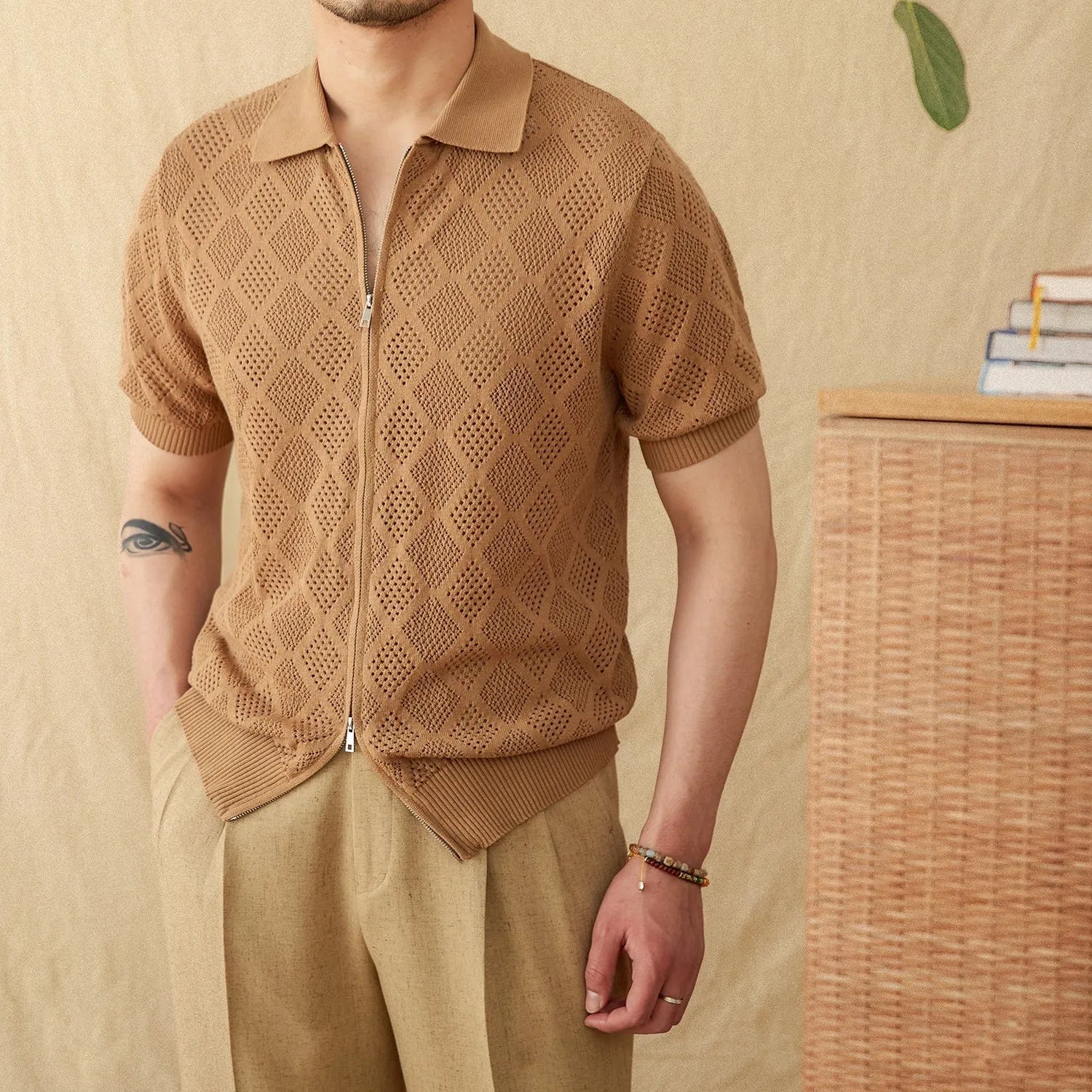 Light brown cotton short sleeve cardigan with zip front and lapel collar laid flat.