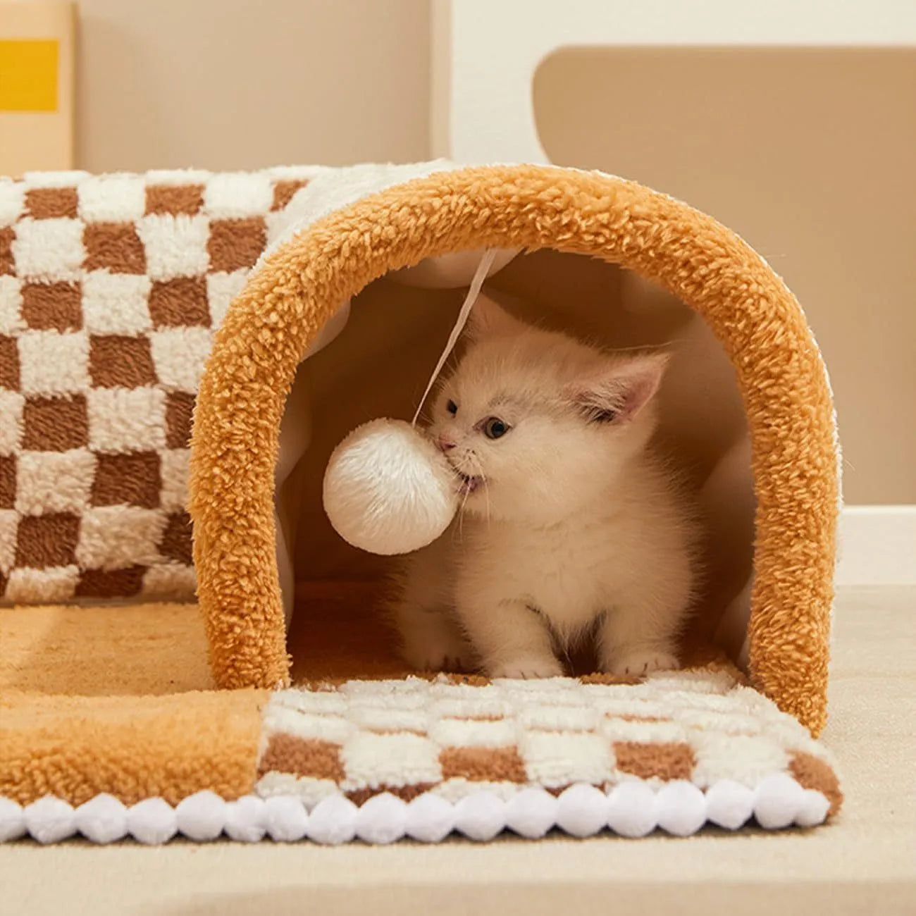 A plush fan-shaped dog and cat bed with an integrated tunnel, shown in a yellow plaid design.
