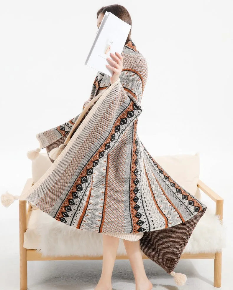 Bohemian style acrylic blanket with tassel fringe on a sofa, shown in a geometric print colour.