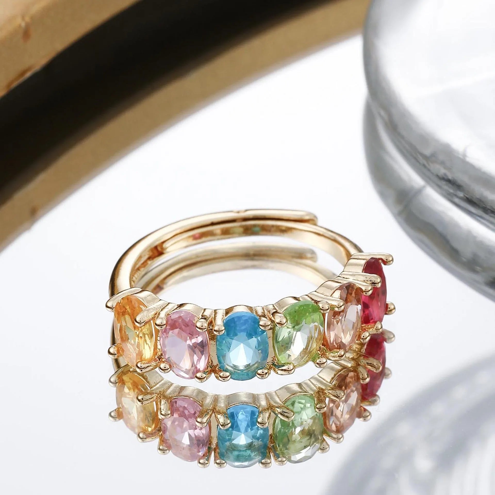 Gold coloured adjustable zircon ring for women on a simple background