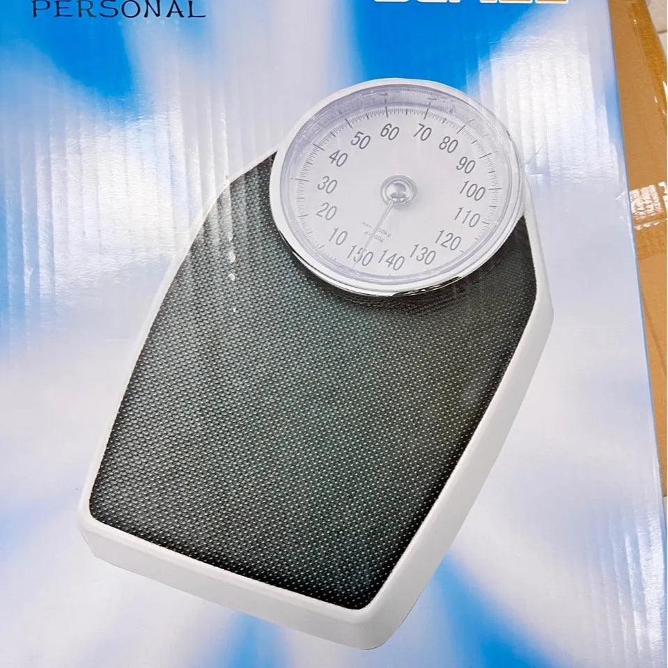 Black mechanical bathroom weight scale with large analogue dial on a simple platform.