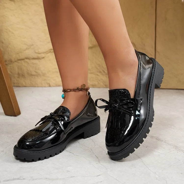Brown women's pointed-toe loafers with a fabric bow detail on the vamp.