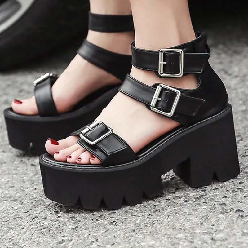 Black women's punk-style platform sandals with a chunky heel, thick sole, round toe, and back zipper.