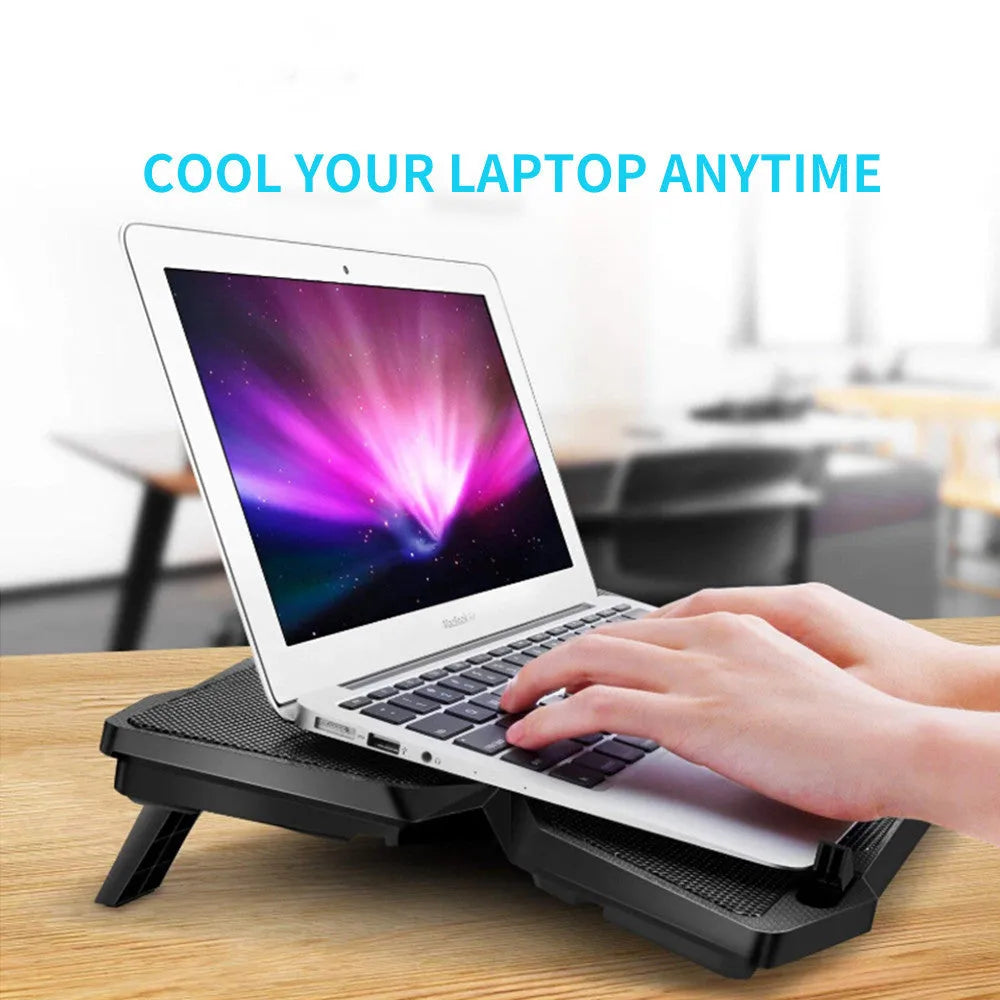 Blue computer cooling base with four LED fans and USB ports on desktop