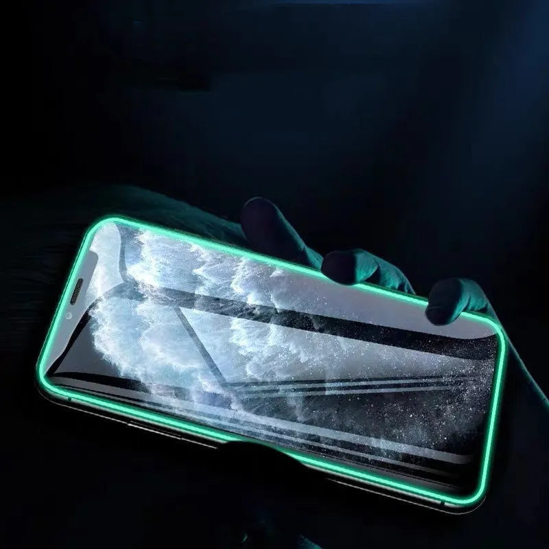 Luminous tempered glass screen protector glowing in the dark next to an iPhone.