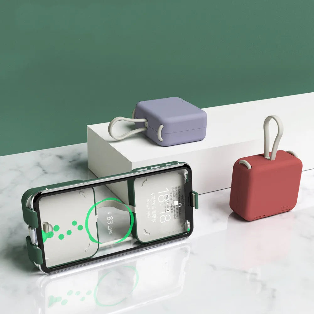 Handbag clip-on power bank in blue showing USB-A and Type-C ports, with phone propped in its integrated stand.