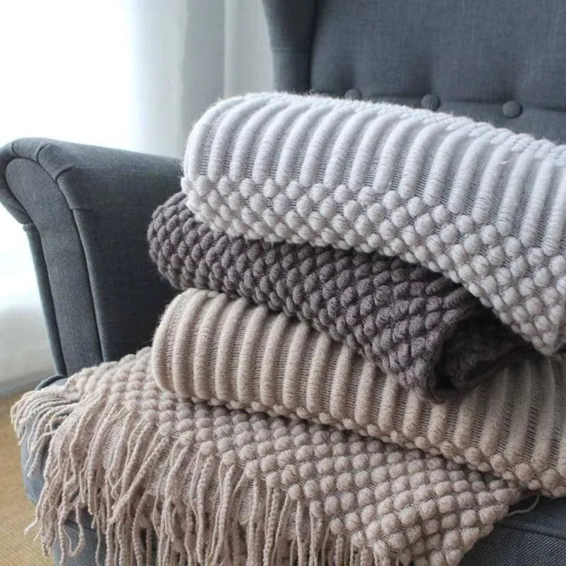 Small grey polyester nap blanket measuring 127 by 170 centimetres folded on sofa