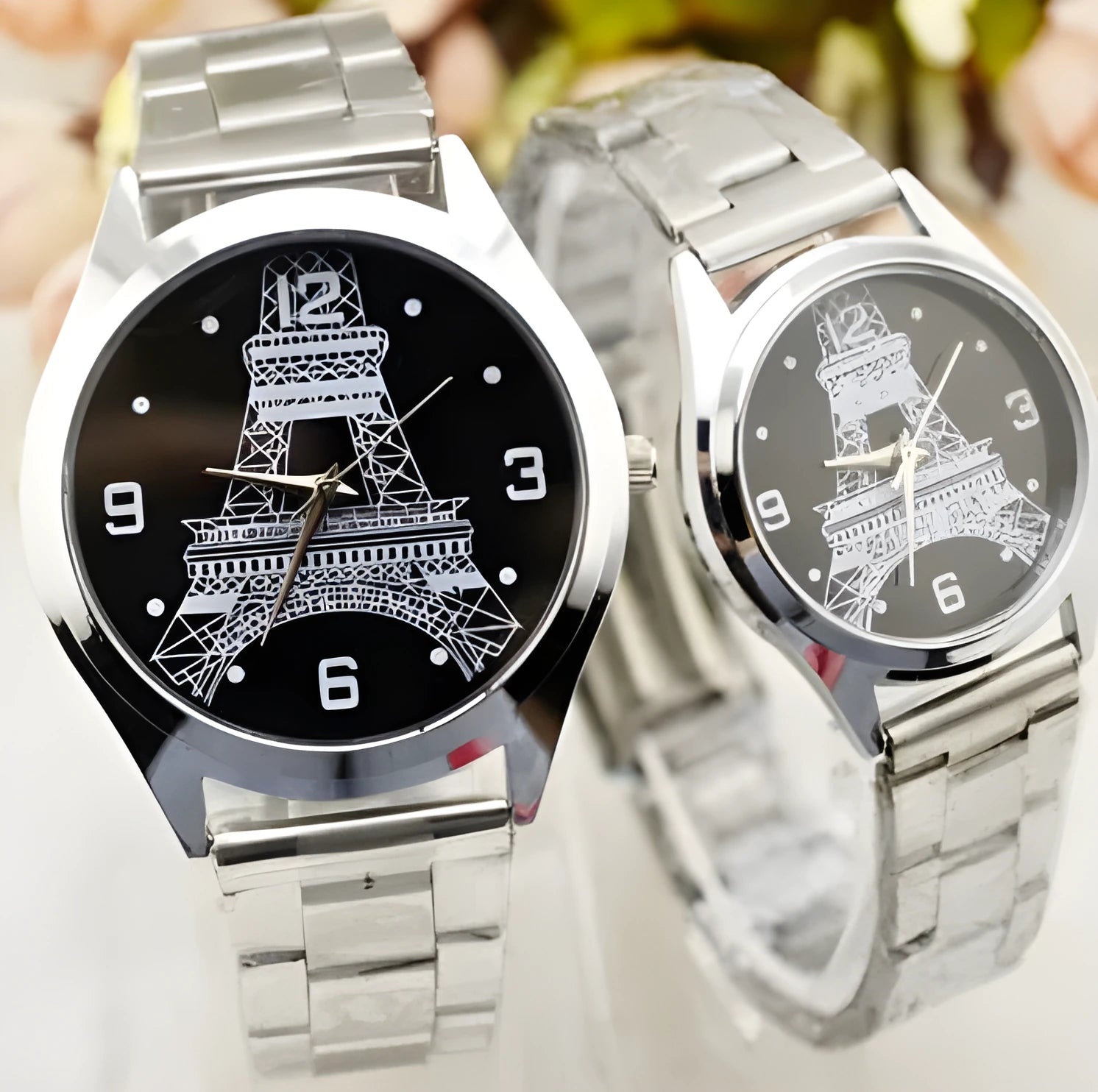 Eiffel Tower analogue wrist watch with stainless steel case, shown in men's and women's styles.