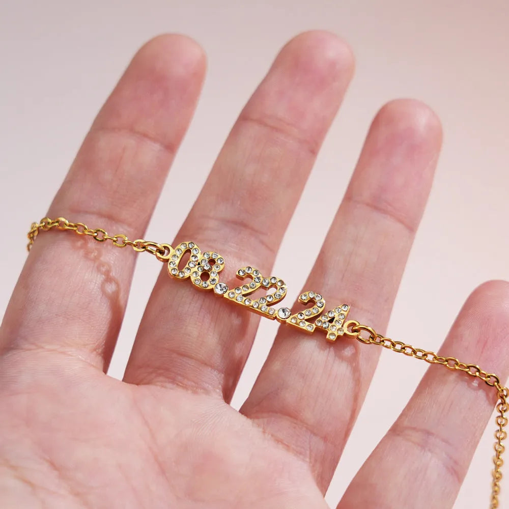 Stainless steel digital bracelet with diamond-studded face on a wrist.