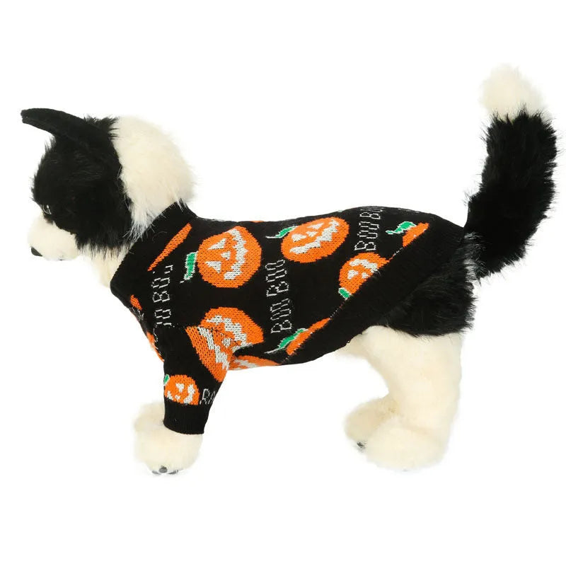 Black dog sweater with a large orange Halloween pumpkin pattern on the back, laid flat.