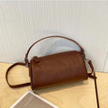 Genuine leather cylindrical crossbody bag for mobile phones in a street style, shown in brown.