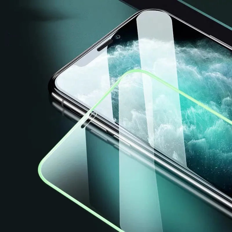 Luminous tempered glass screen protector glowing in the dark next to an iPhone.