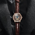 Men's waterproof mechanical watch with stainless steel strap, round dial, and transparent case back showing the movement.