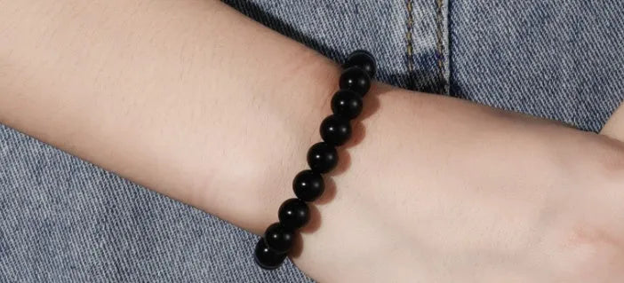 Geometric black agate bracelet with 8mm beads on a black elastic cord for women.