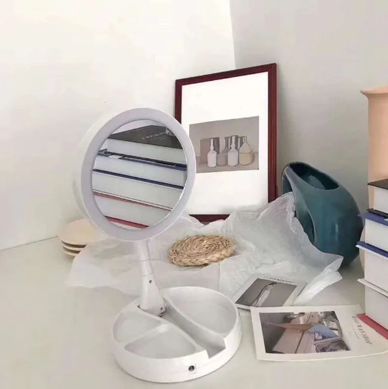 White foldable LED vanity mirror with storage tray and USB cable.