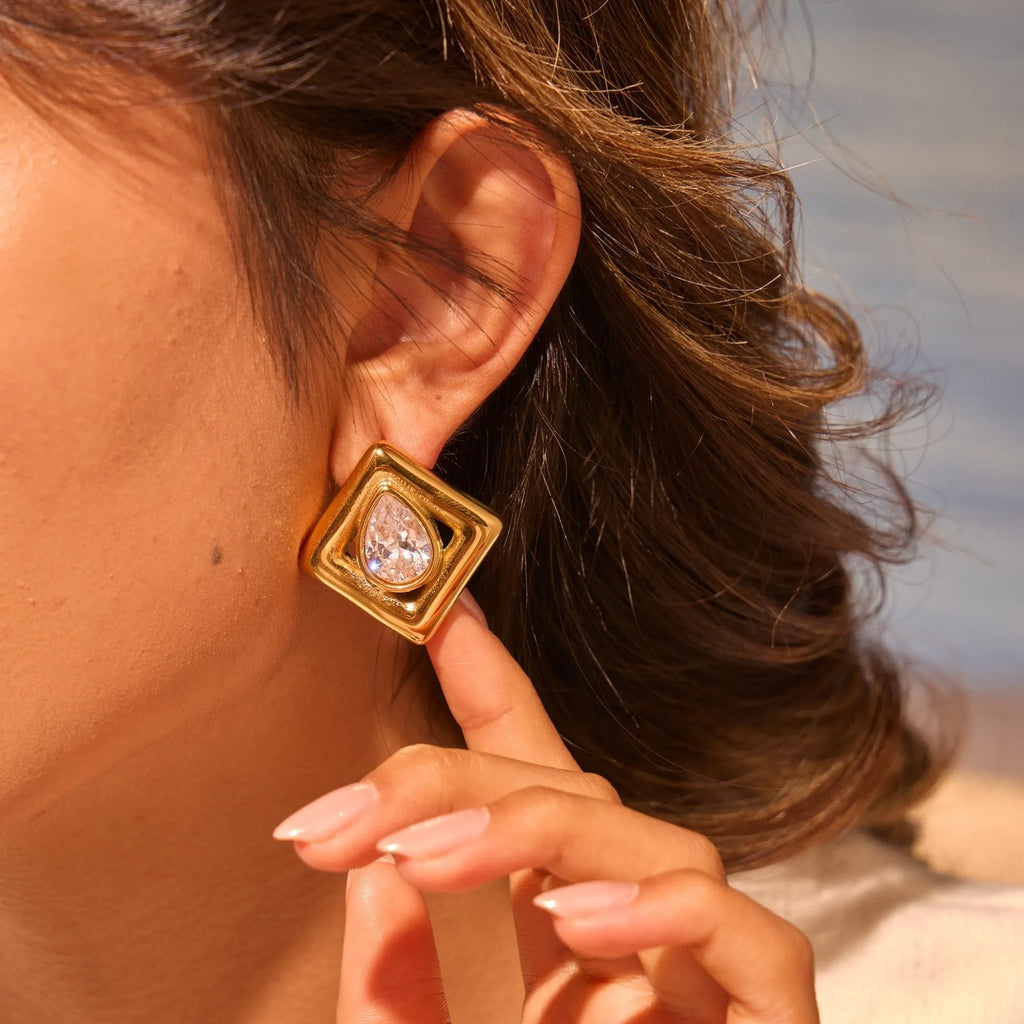 Gold-coloured geometry stud earrings with inlaid water drop zircon stones on a stainless steel base.
