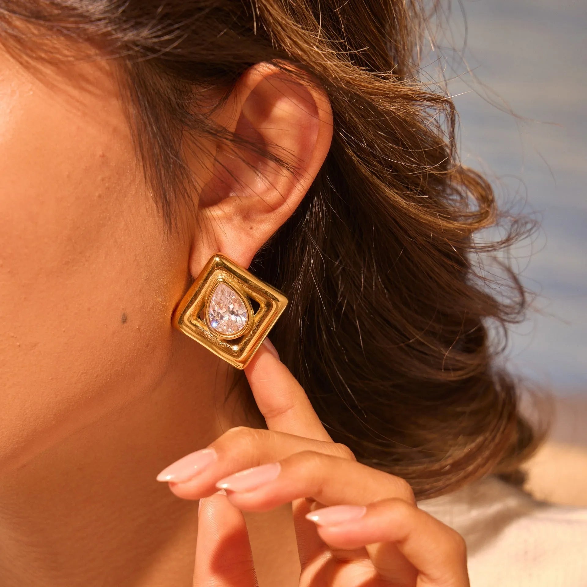 Gold-coloured geometry stud earrings with inlaid water drop zircon stones on a stainless steel base.