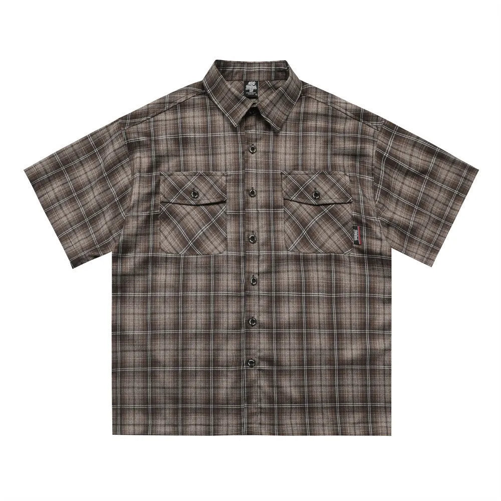 Man wearing a brown plaid short sleeve shirt with embroidery on the lapel