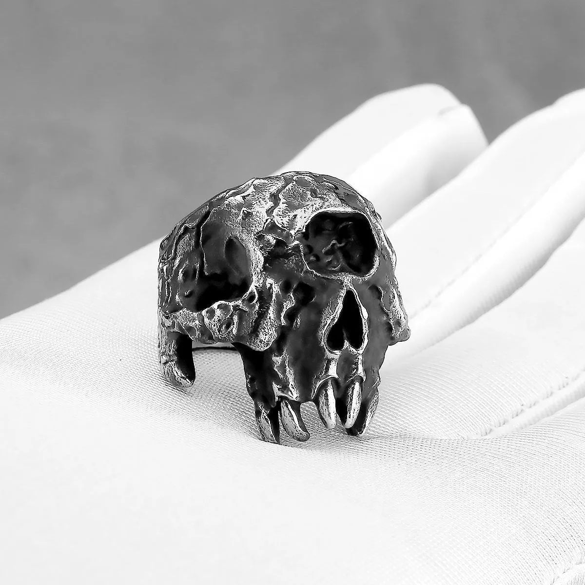 Silver-toned alloy skull ring with a detailed one-eyed design on a black background.