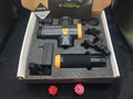 Black fascia gun massage tool with four removable heads on grey background