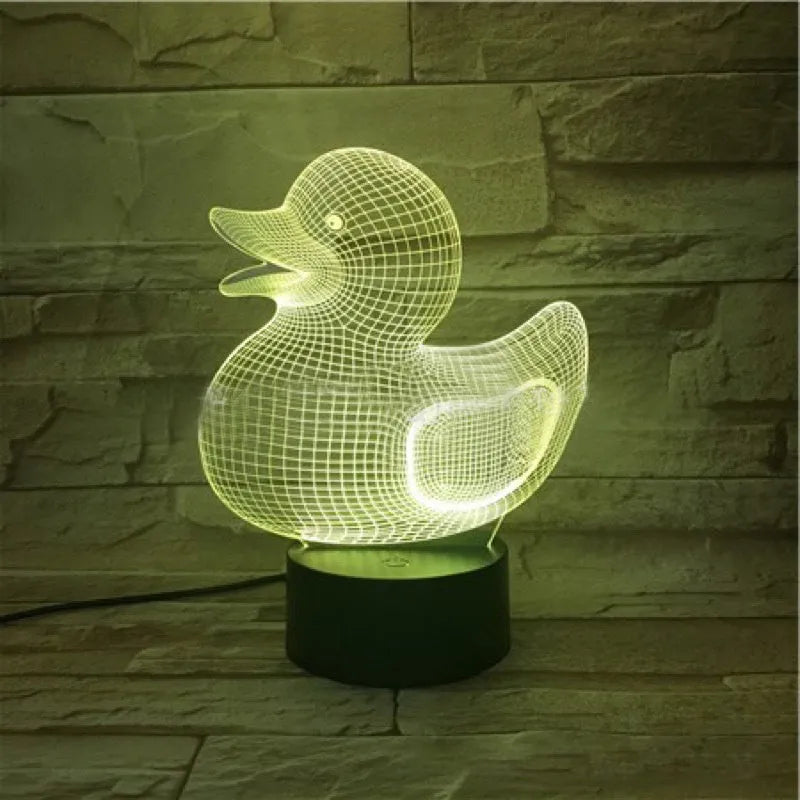 Little yellow duck 3D night light on a table showing its cartoon design and colourful illumination.