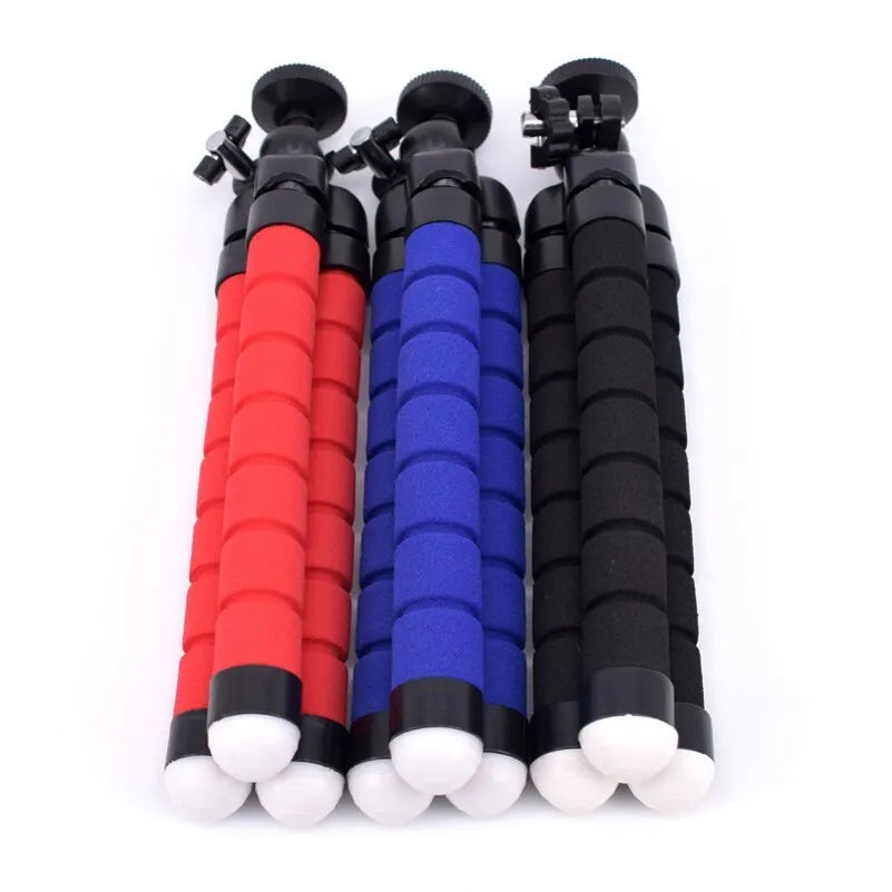 Black mini flexible octopus tripod with wrapped legs next to a smartphone.