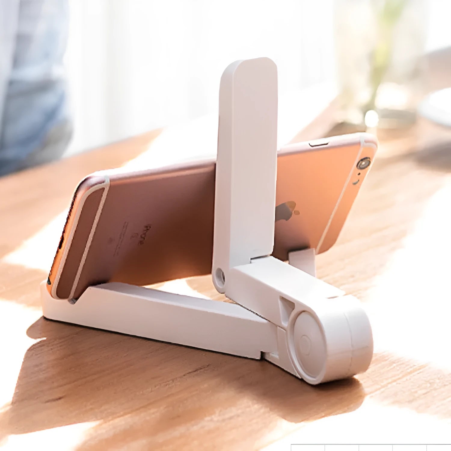 Black foldable tablet holder open on a desk supporting a tablet in landscape mode.