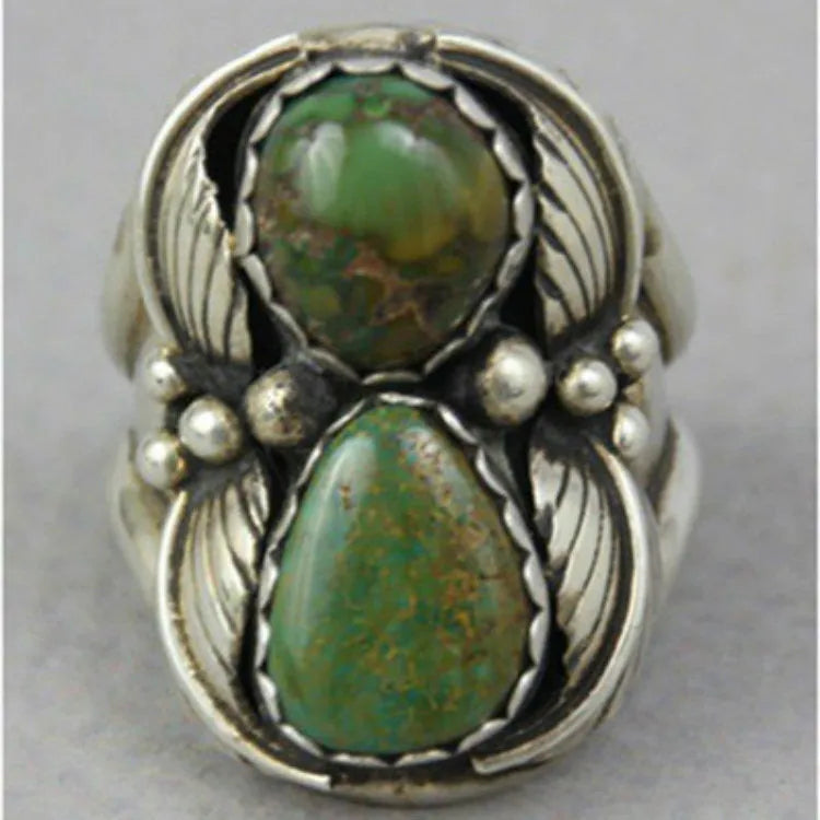 Geometric silver-toned women's ring with a central inlaid turquoise blue stone on a white background.