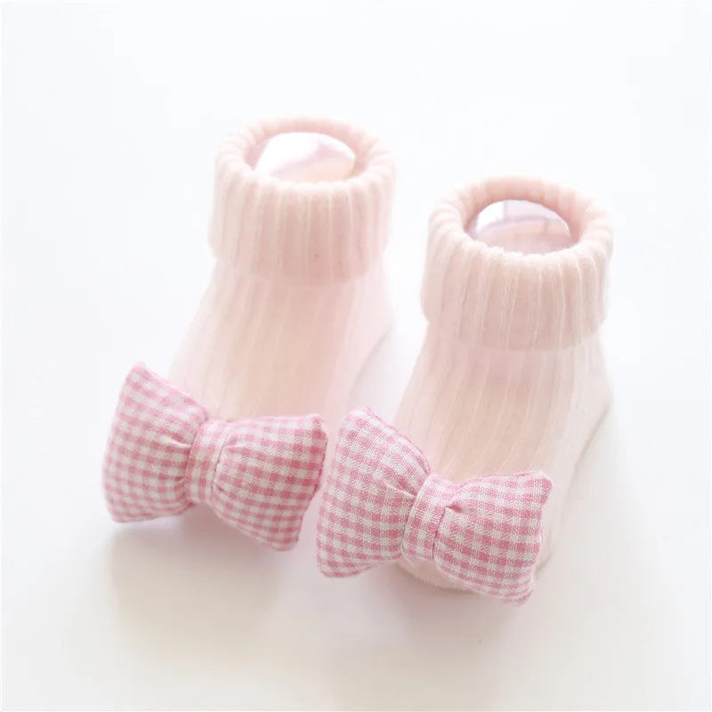 Cotton baby floor socks in various designs including blue bow and lion, showing sizes for infants 0-3 months