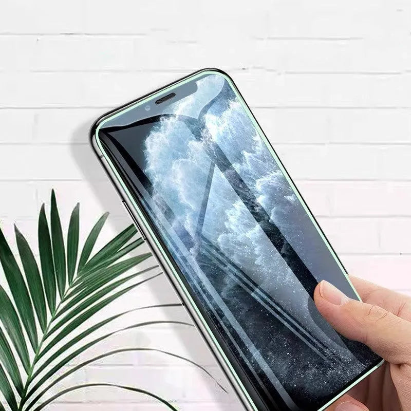Luminous tempered glass screen protector glowing in the dark next to an iPhone.