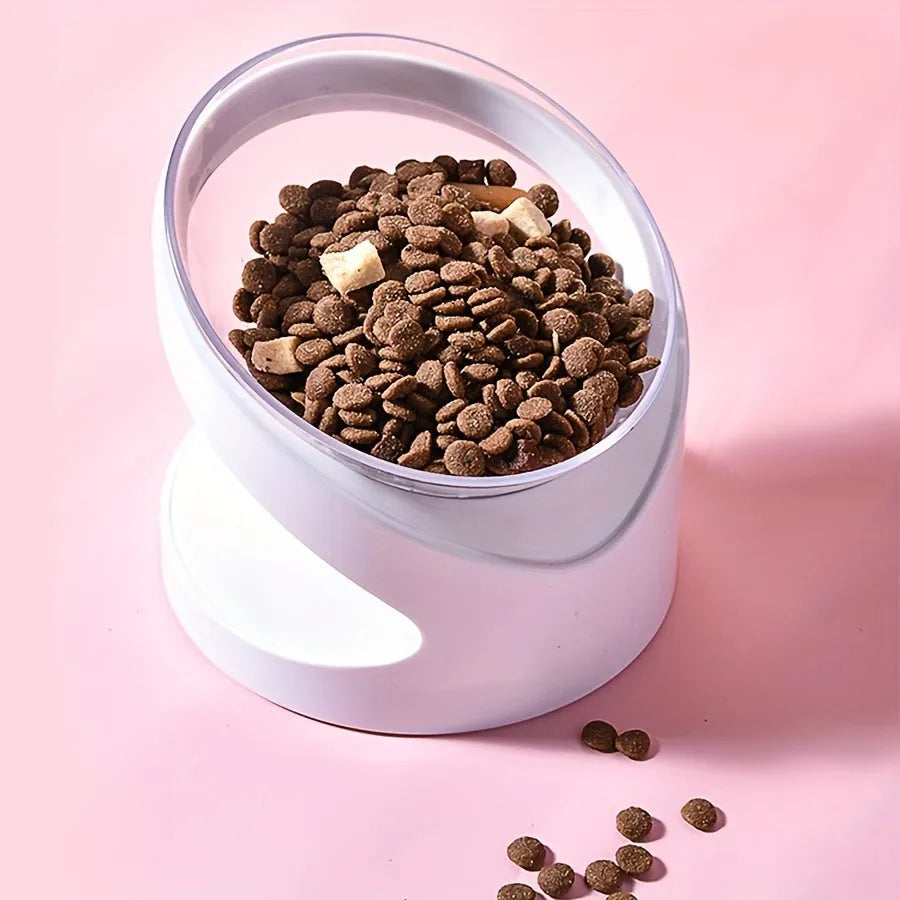 White clear plastic tilted cat food bowl on a flat surface.