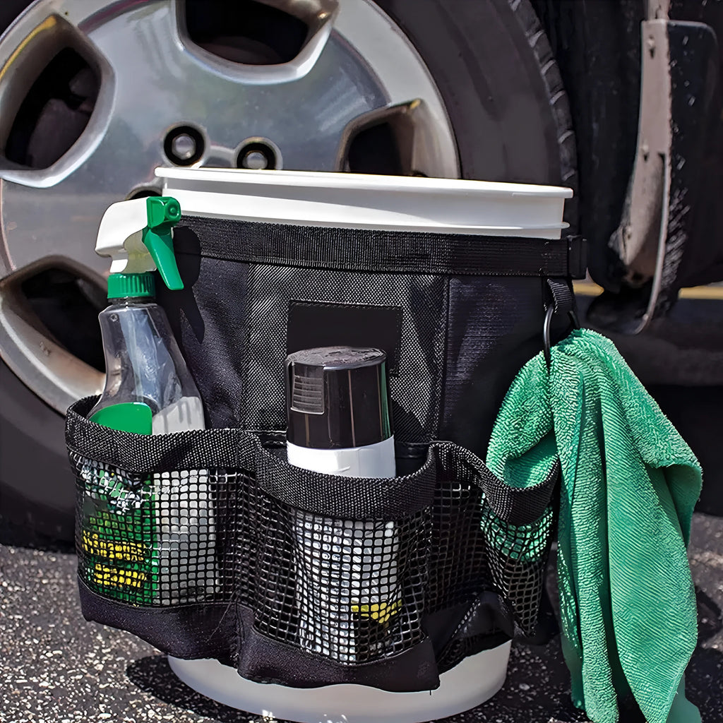Black cylindrical polyester storage bag hanging on a 5-gallon water barrel for organising tools and gear.
