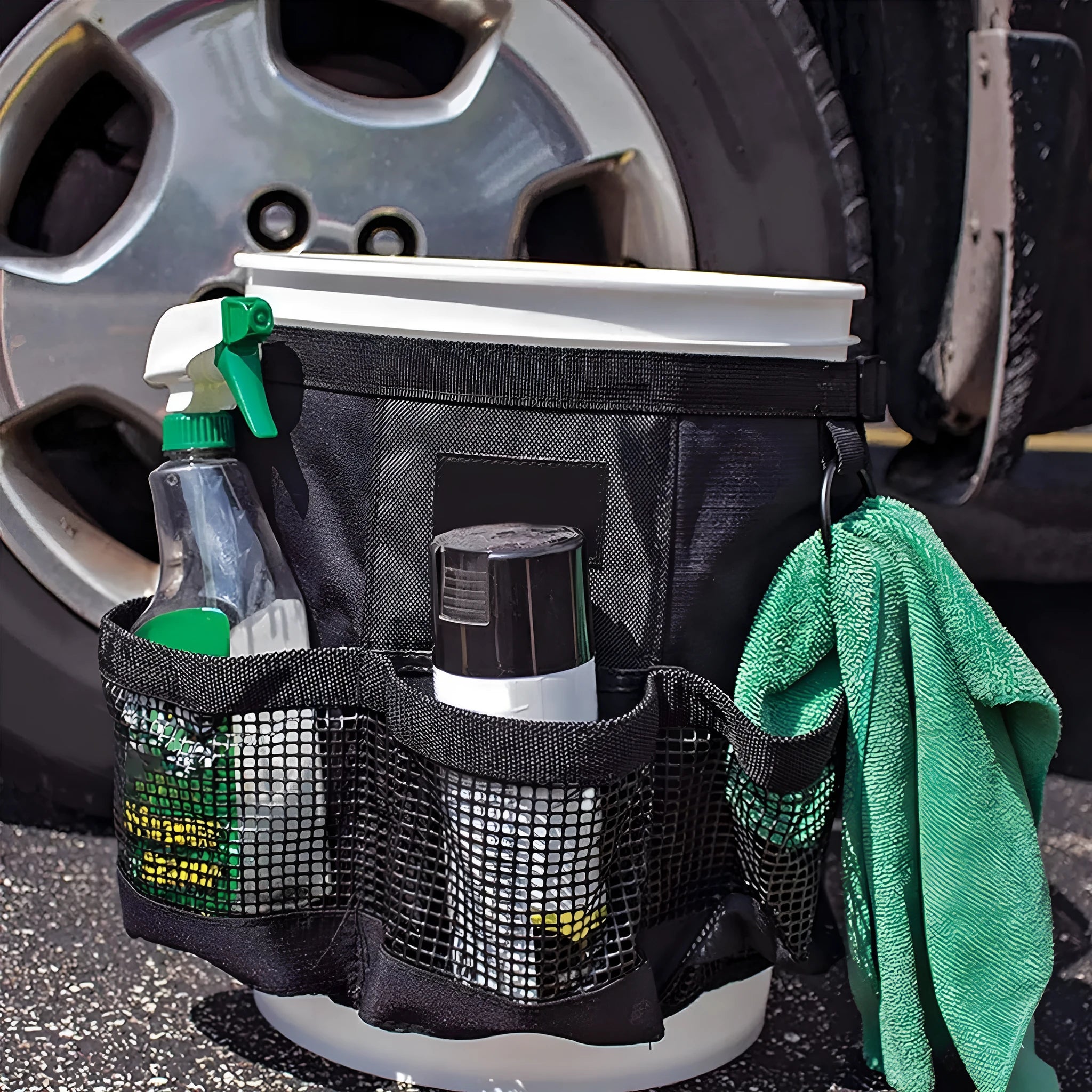 Black cylindrical polyester storage bag hanging on a 5-gallon water barrel for organising tools and gear.