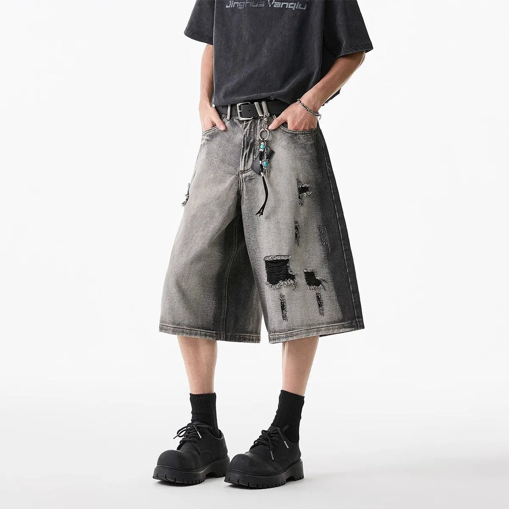 Grey women's denim shorts with distressed hole details and a loose, cropped fit