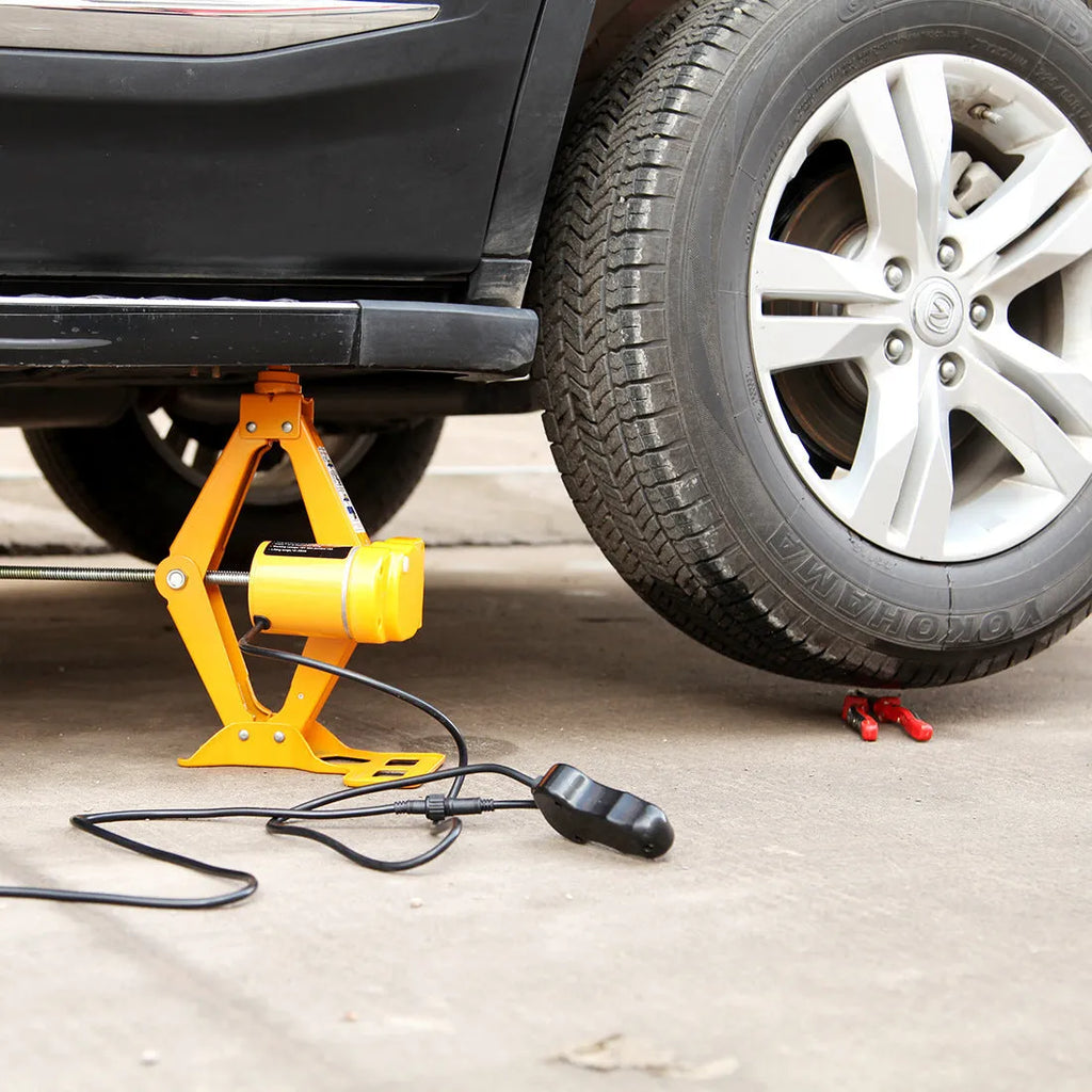 Electric hydraulic car jack kit with 2 tonne lifting capacity mounted in a vehicle boot.
