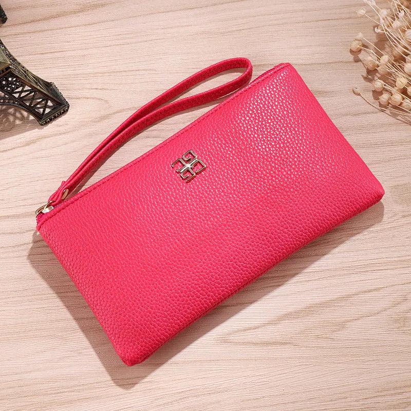 Long wine red PU leather zip wallet handbag worn crossbody, showing card slots and sewing line detail.