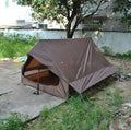Brown and white pole-free A-line cabin tent set up with hiking canes, showing spacious interior
