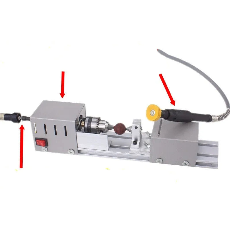 Silver metal manual mini woodworking lathe with carving tools on a workbench.