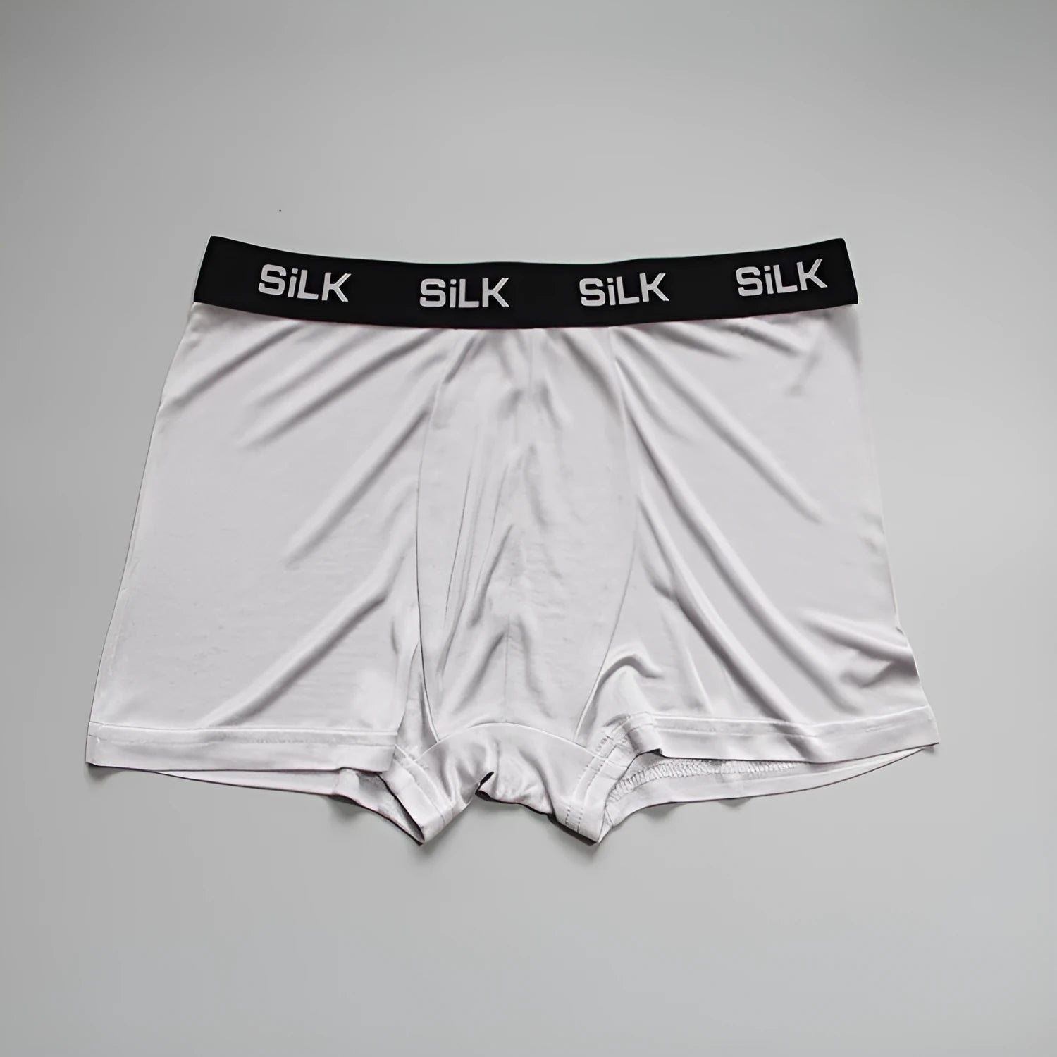 Men's loose fit silk shorts in navy blue on a neutral background