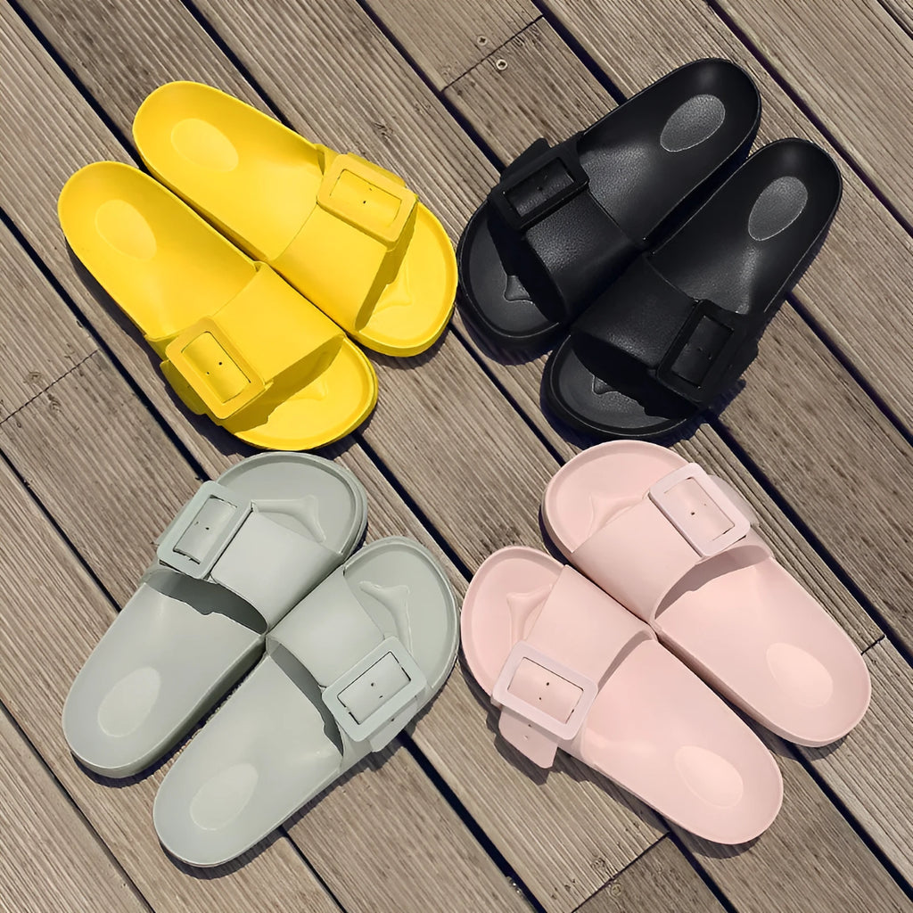 Women's grey blue flip flop slippers with a silver buckle on the strap and a textured EVA sole.