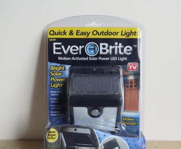 Four white solar-powered LED motion sensor lights for outdoor garden and pathway use.