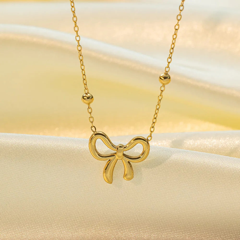 Gold-colour titanium steel necklace with a bow pendant on an adjustable chain