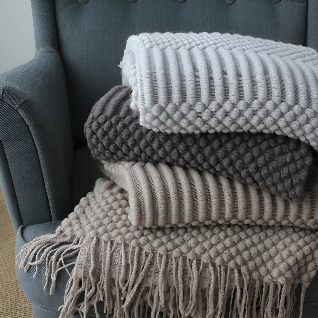 Small grey polyester nap blanket measuring 127 by 170 centimetres folded on sofa