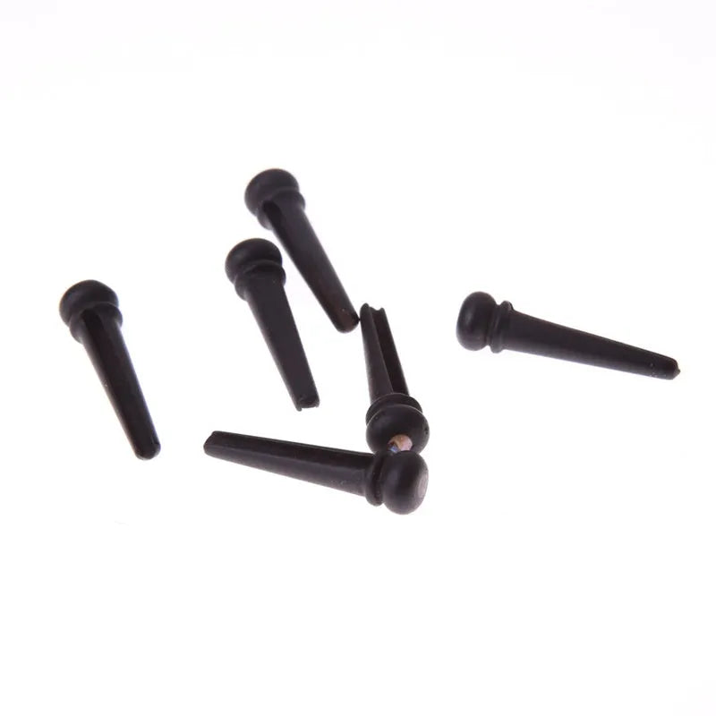 Six solid ebony guitar string nails with matte black finish for folk acoustic guitars