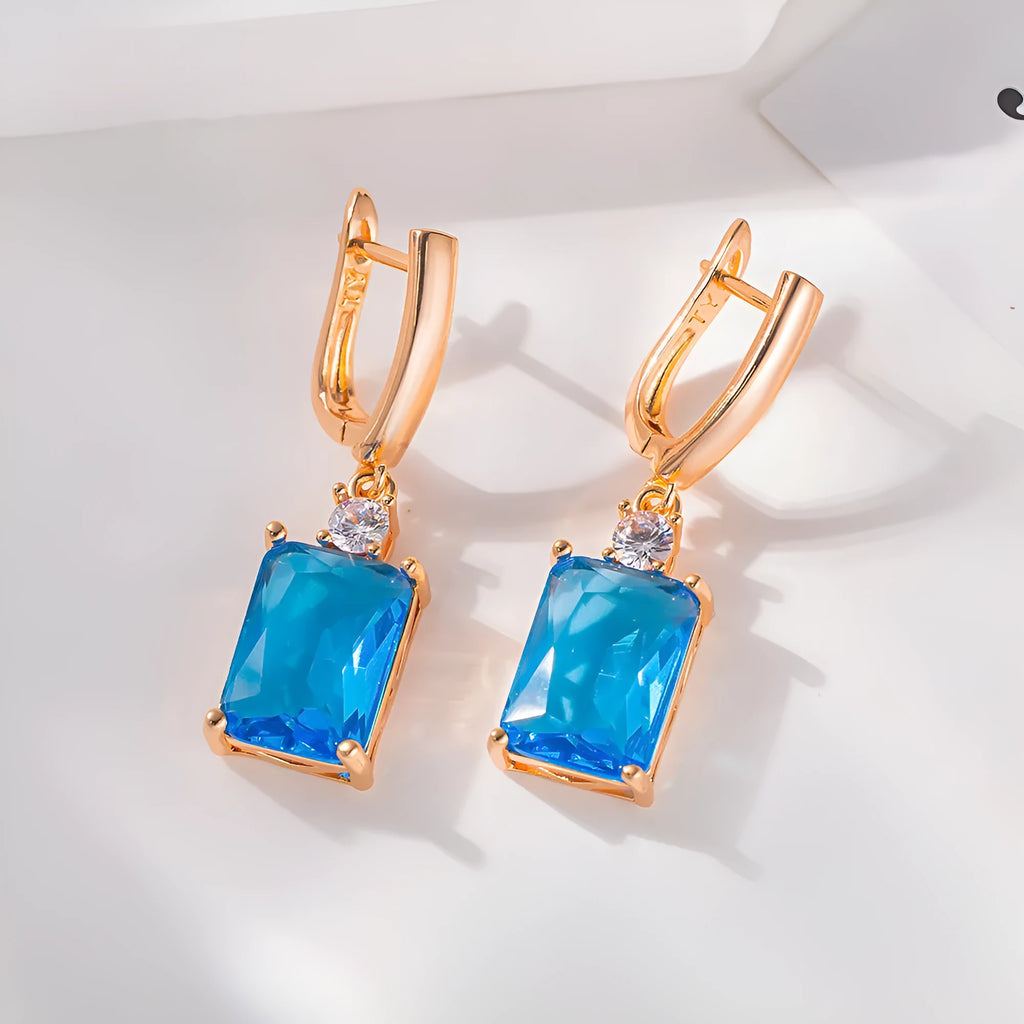 A pair of square-shaped gold and silver electroplated copper earrings showing front view.
