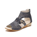 Women's beige rivet flat sandals with fish mouth toe and back zipper on a low wedge heel.
