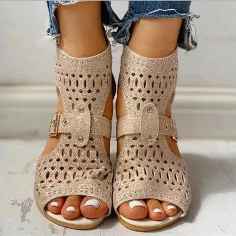 Women's beige rivet flat sandals with fish mouth toe and back zipper on a low wedge heel.