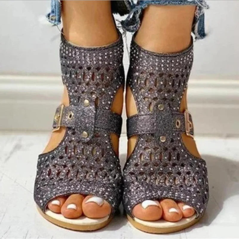 Women's beige rivet flat sandals with fish mouth toe and back zipper on a low wedge heel.