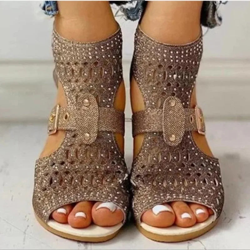 Women's beige rivet flat sandals with fish mouth toe and back zipper on a low wedge heel.