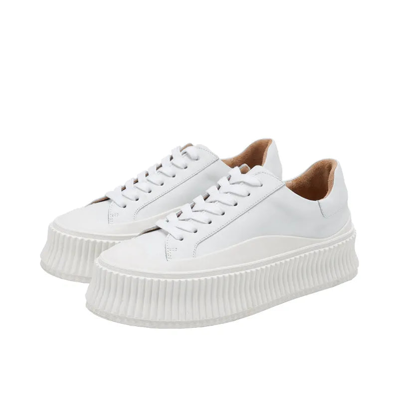 Women's white and black chunky platform shoes with back lacing and a thick rubber sole.